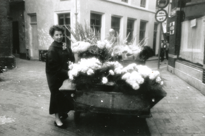 875276 Portret van mevr. Veenendaal-van Zuilen uit Wijk C bij haar bloemenkar op de hoek van de Rozenstraat en de ...